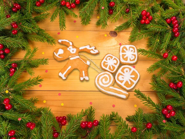 Reno con galletas de regalo en el marco del árbol de Navidad — Foto de Stock