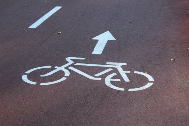 Kırmızı Asfaltta Beyaz Bisiklet Yolu İşareti ve Yön Oku