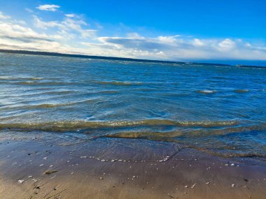 Dalgalar ve Kentsel Skyline siluetiyle Güneşli Baltık Deniz Sahil Çizgisi
