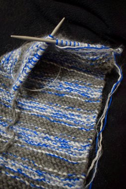 Evde yün iplikle el örgüsü örüyorum.