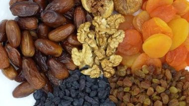 Bir tabakta yavaşça kurutulmuş meyve ve fındık, üst görünüm