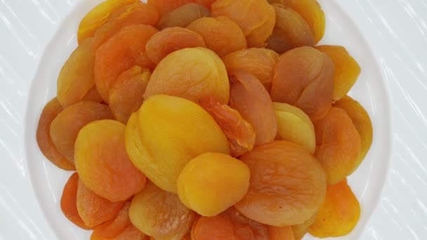 Slowly Rotating Dried Apricots Plate White Background Top View — Stock Video