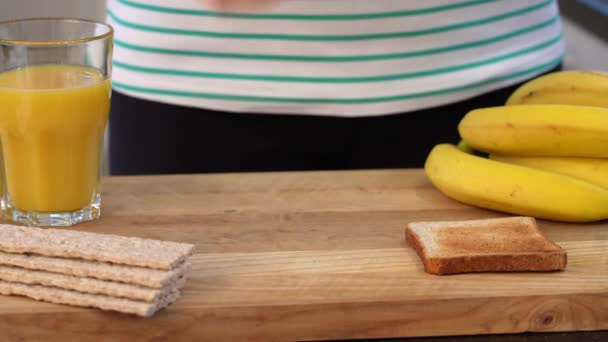 キッチンで健康的な朝食を準備する ピーナッツバター バナナ ジュース ナッツとトースト — ストック動画