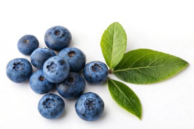 Canlı yeşil yapraklar üzerinde toplanmış taze yaban mersinleri ve narin çiğ taneleri..