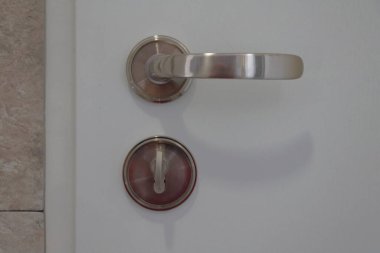 Beyaz bir kapının kolu. Yakın çekim görünümü.