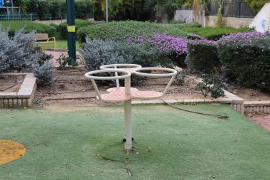 Parktaki oyun parkında yeşil çimenler ve çiçekler.