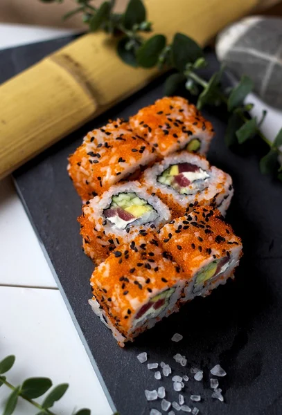 Rollos con atún, queso crema, aguacate, pepino y caviar tobiko — Foto de Stock