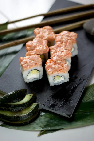 Rollos con salmón, queso crema, aguacate, pepino y caviar Masago — Foto de Stock