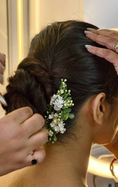 Bir stilist, düğün hazırlıkları sırasında zarif bir çöreği güvence altına alarak, zanaatkarlık, güzellik ve geleneksel zarafeti ön plana çıkarıyor..