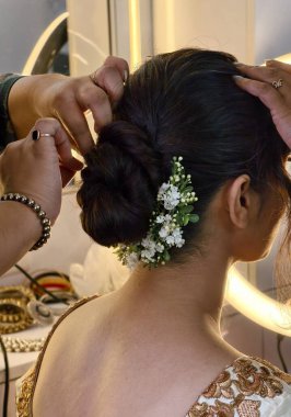 Bir stilist olarak gelinlik kuaförlüğü, Hintli bir gelin için çiçekli bir çörek temin ediyor. Detaylı düğün hazırlıklarını, zarafeti ve geleneksel güzelliği sahne arkasında yakalıyor..