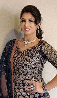 Zarif bir Hintli kadın, tasarımcı kıyafetiyle takı takıyor, zarif bir parti görüntüsü sergiliyor, kendine güvenen bir stil ve modern geleneksel moda..