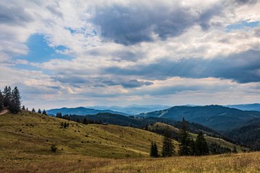 Dağları ve mavi gökyüzü olan güzel bir manzara.