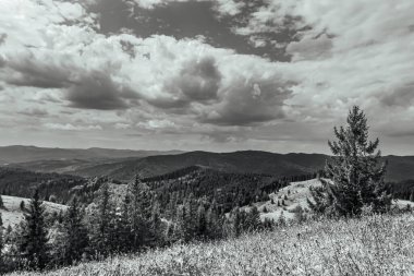 a beautiful shot of the mountains with a cloudy sky in the background