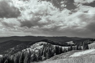 a vertical shot of the black and white clouds in the mountains