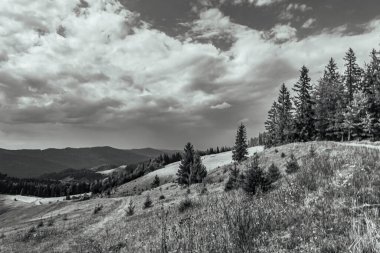 a beautiful landscape of a mountain range under a cloudy sky on a sunny day