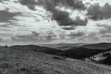 a vertical grayscale shot of the mountains with a cloudy sky