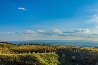 Dağları ve mavi gökyüzü olan güzel bir manzara.