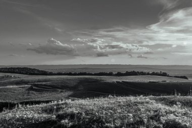 black and white clouds over the countryside landscape. black and white image.