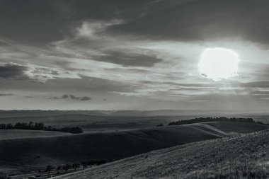 beautiful sunrise over a field of grass and hills
