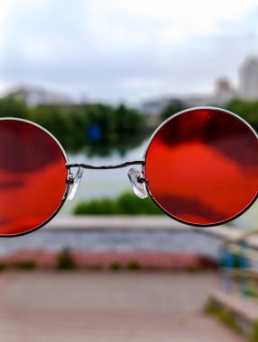 Kırmızı güneş gözlüklerinin aynasında yansıyor.