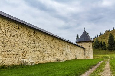 Tepedeki eski ahşap evin manzarası.