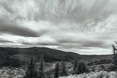 Karpatlar 'daki kayalık bir dağın üzerinde siyah ve beyaz bulutlar