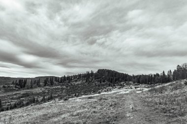 Dağlar arasında siyah beyaz bulutlar