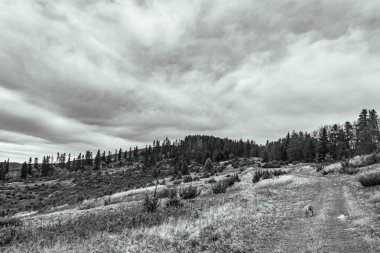Dağların üzerinde siyah beyaz bulutlar