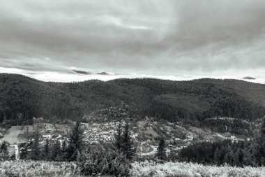 Yazın dağların tepesinde siyah beyaz bulutlar.