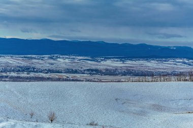 Kar ve bulutlarla dolu güzel bir manzara.