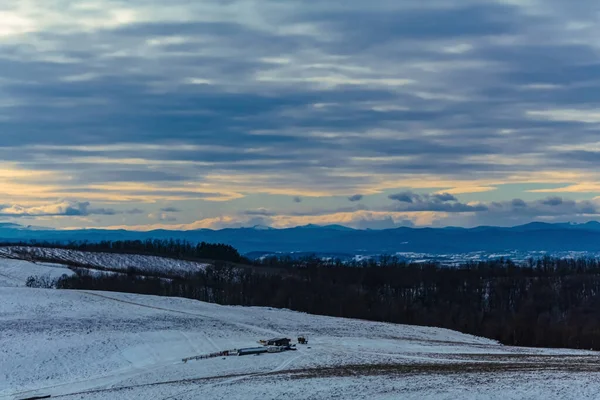 Kış manzarası karla kaplı tarlalar ve dağlarla