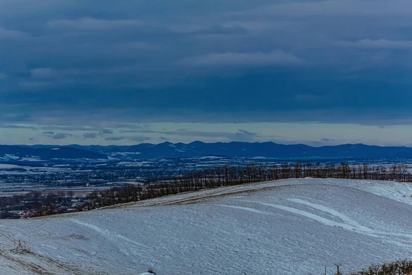 Dağları ve bulutlu gökyüzü olan güzel bir manzara.