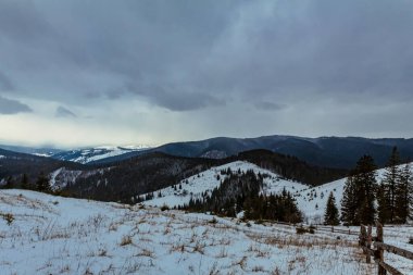 Karlı dağlarla kaplı kış manzarası.