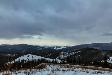 a beautiful shot of snow covered mountains in the winter in the cloudy sky