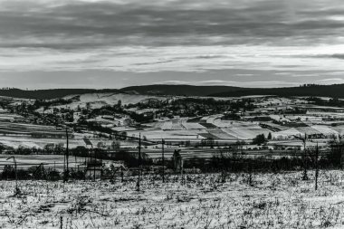 Dağları gören kırsal bir manzaranın siyah beyaz fotoğrafı.