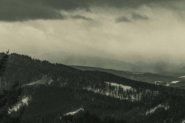 Arkasında kar olan dağların siyah beyaz görüntüsü