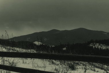 Karla kaplı eski bir ahşap çitin alçak açılı görüntüsü.