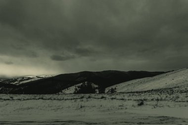 Uzakta bir dağ olan karlı bir arazinin dikey görüntüsü.