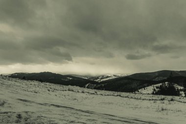Karlı ve bulutlu gökyüzü olan dağ manzarası