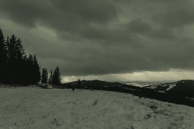 Kışın bulutlu bir gökyüzü ile bir dağın dikey çekimi