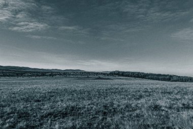 Dağları ve bulutlu gökyüzü olan güzel bir manzara.