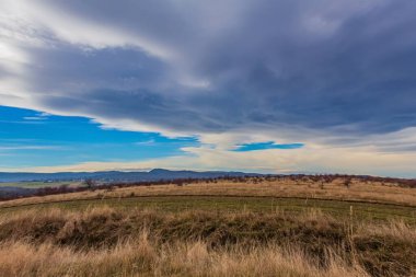 Arkasında bulutlu bir gökyüzü olan güzel bir tarla manzarası