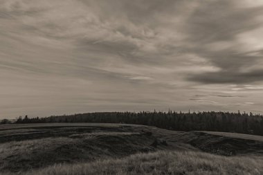 Köyün tepelerinde siyah beyaz bulutlar