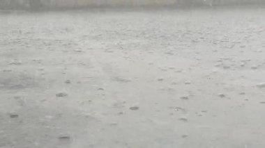 Yere usulca yağmur damlaları yağıyor.