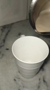 Sıcak kahve fincana dökülüyor.