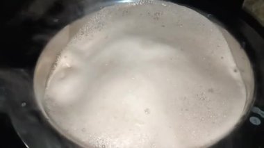 Kahve potada yavaşça kaynıyor. Alışveriş merkezi kabarcıkları yüzeyden yükseliyor. Buhar yükseliyor, sıcak bir koku yayıyor. Koyu kahverengi kahve içmeye hazır görünüyor..