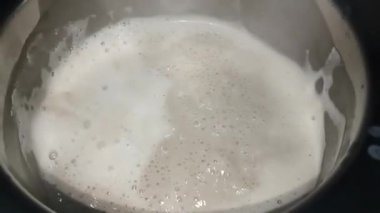 Kahve potada yavaşça kaynıyor. Alışveriş merkezi kabarcıkları yüzeyden yükseliyor. Buhar yükseliyor, sıcak bir koku yayıyor. Koyu kahverengi kahve içmeye hazır görünüyor..