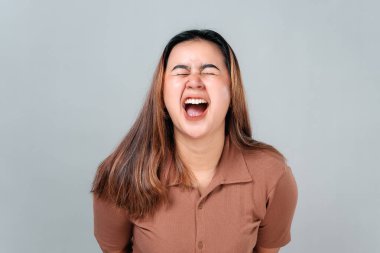 Uzun saçlı genç bir Asyalı kadının portresi. Gözleri kapalı ve ağzı açık kahkahalarla gülüyor. Sade bir arka plana karşı yoğun bir sevinç ve hakiki duygu ifade ediyor..