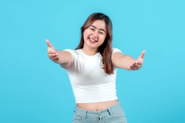Kollarını uzatmış neşeli genç bir kadın, sıcacık bir kucaklaşmaya davet ediyor, parlak mavi bir arka planda, neşe ve dostluk saçıyor..