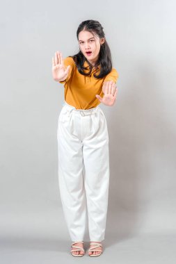 Genç bir kadın dur hareketiyle poz veriyor, reddedilme ya da ihtiyatı elden bırakmıyor. Yüz ve el hareketleri bu resmi reklam için ideal kılıyor..